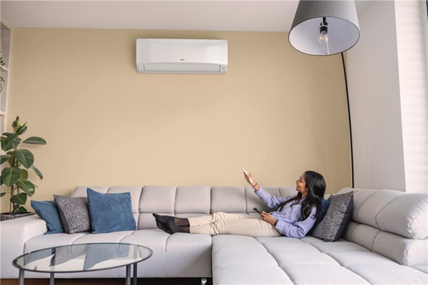 Femme allongée sur un canapé, profitant de la climatisation d’une pompe à chaleur air-air